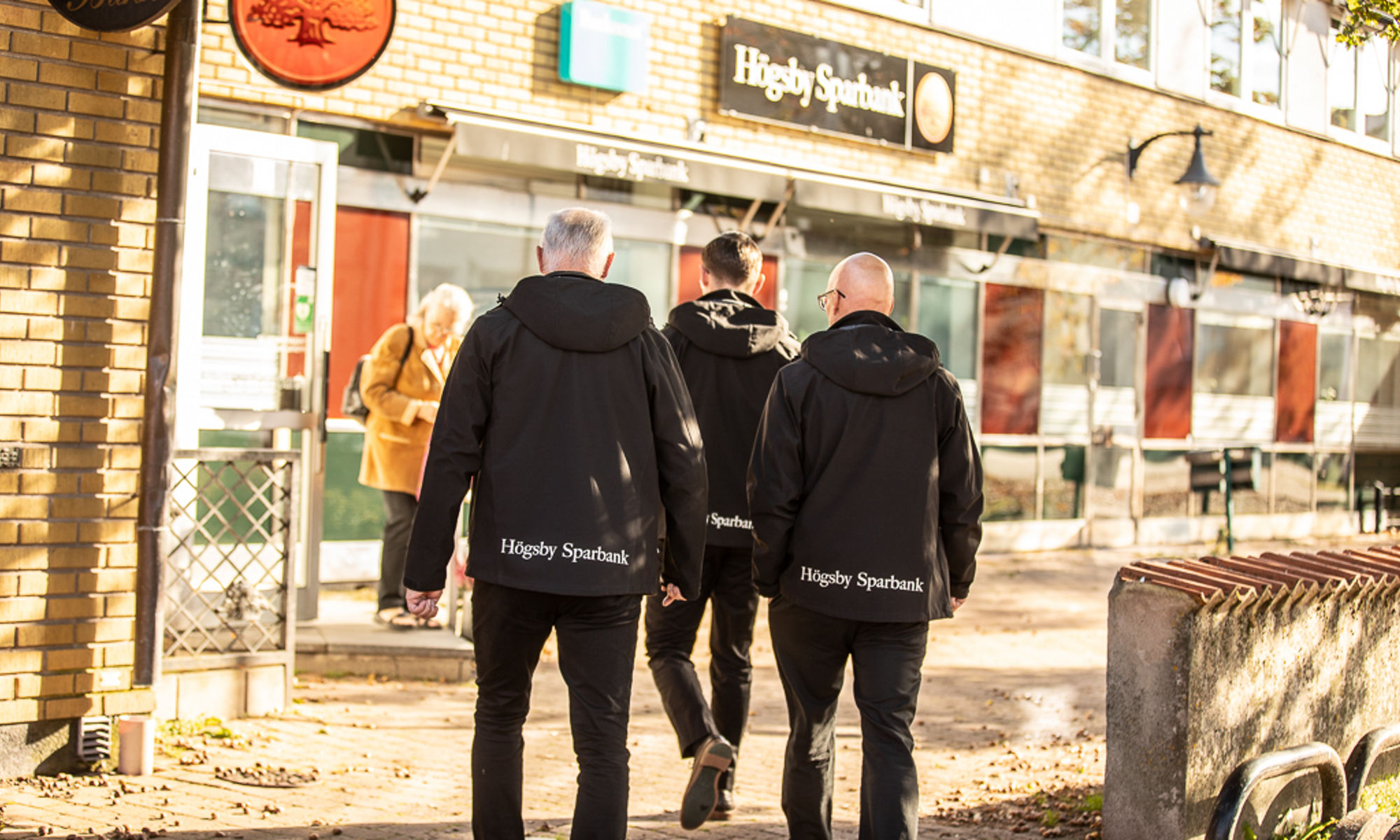 Tre män som går mot bankens lokal 