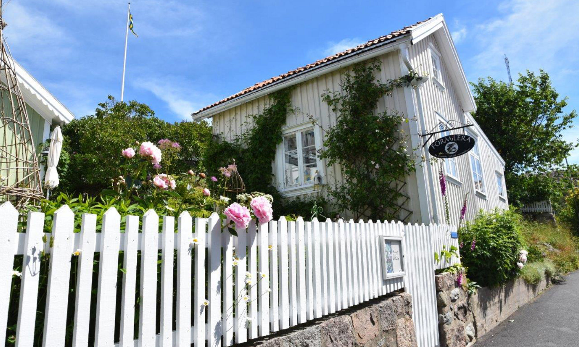 Hus i gammal stil och blommiga buskar i gamla Grebbestad