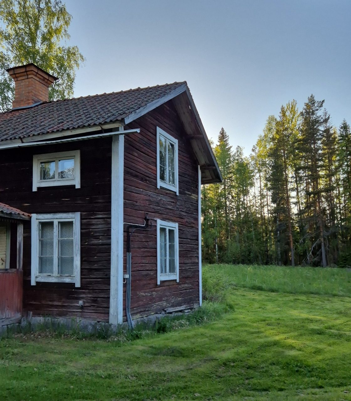 Gammal stuga i dalarna på en sommarkväll