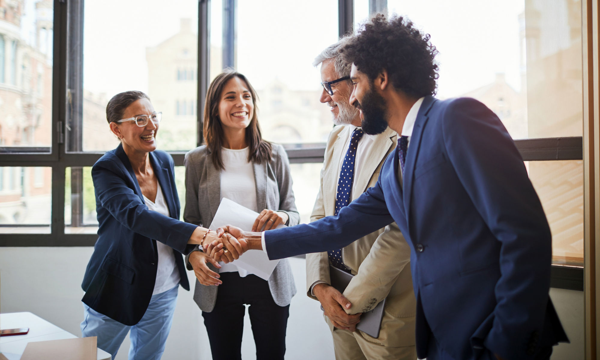 Man in suite shaking hands with a group of people