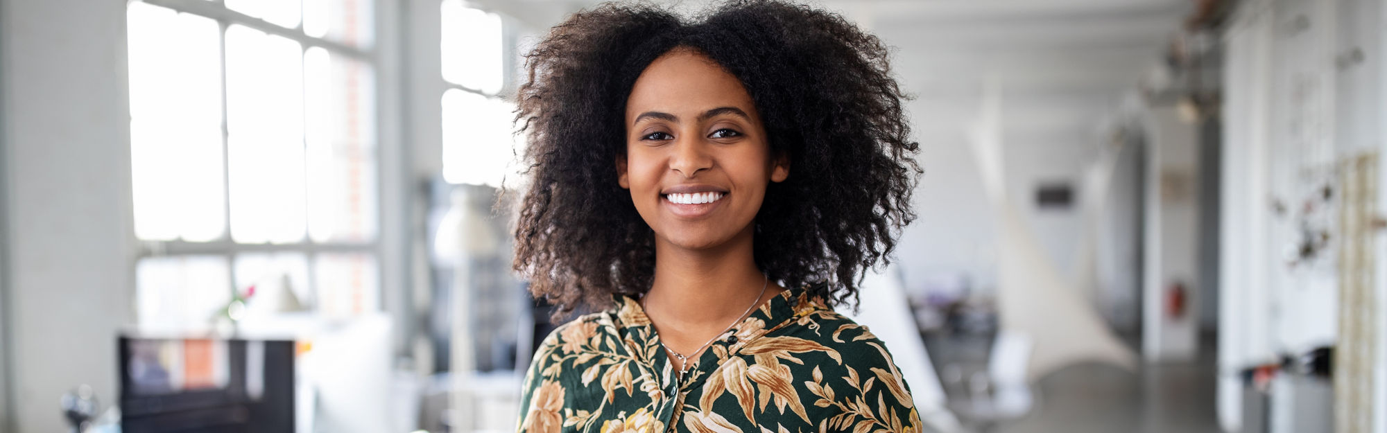 Smiling woman standing with digital tablet in office