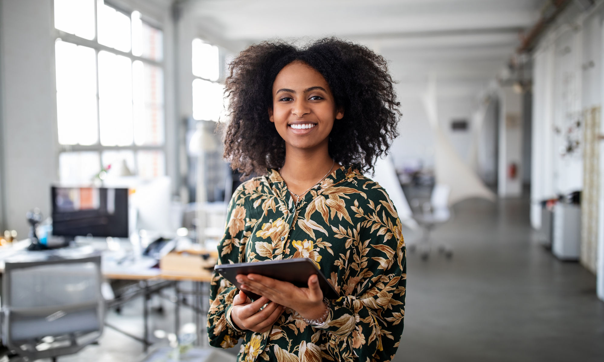 Woman standing with digital tablet in office