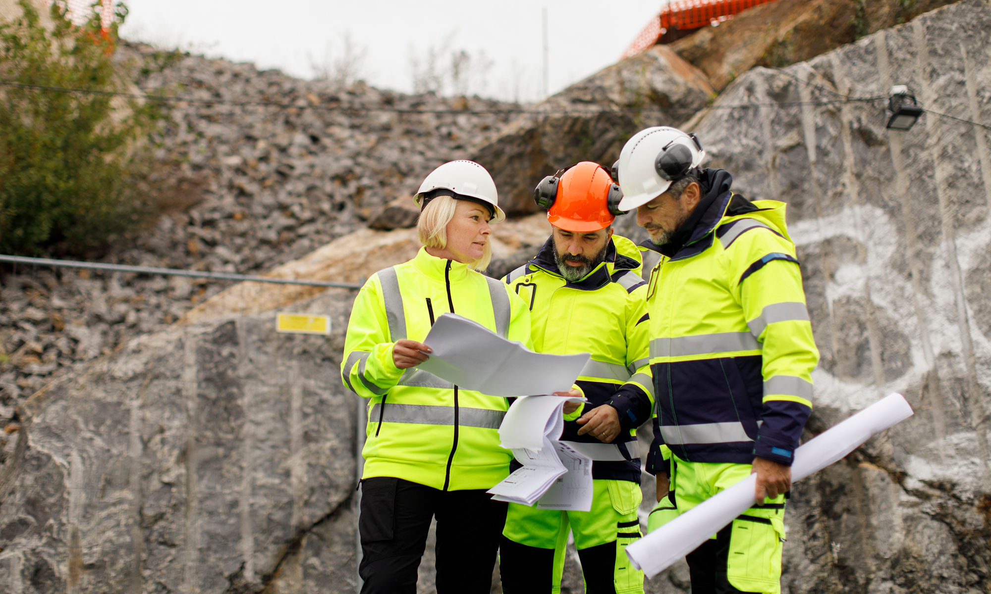 En grupp byggarbetare har ett planeringsmöte utomhus