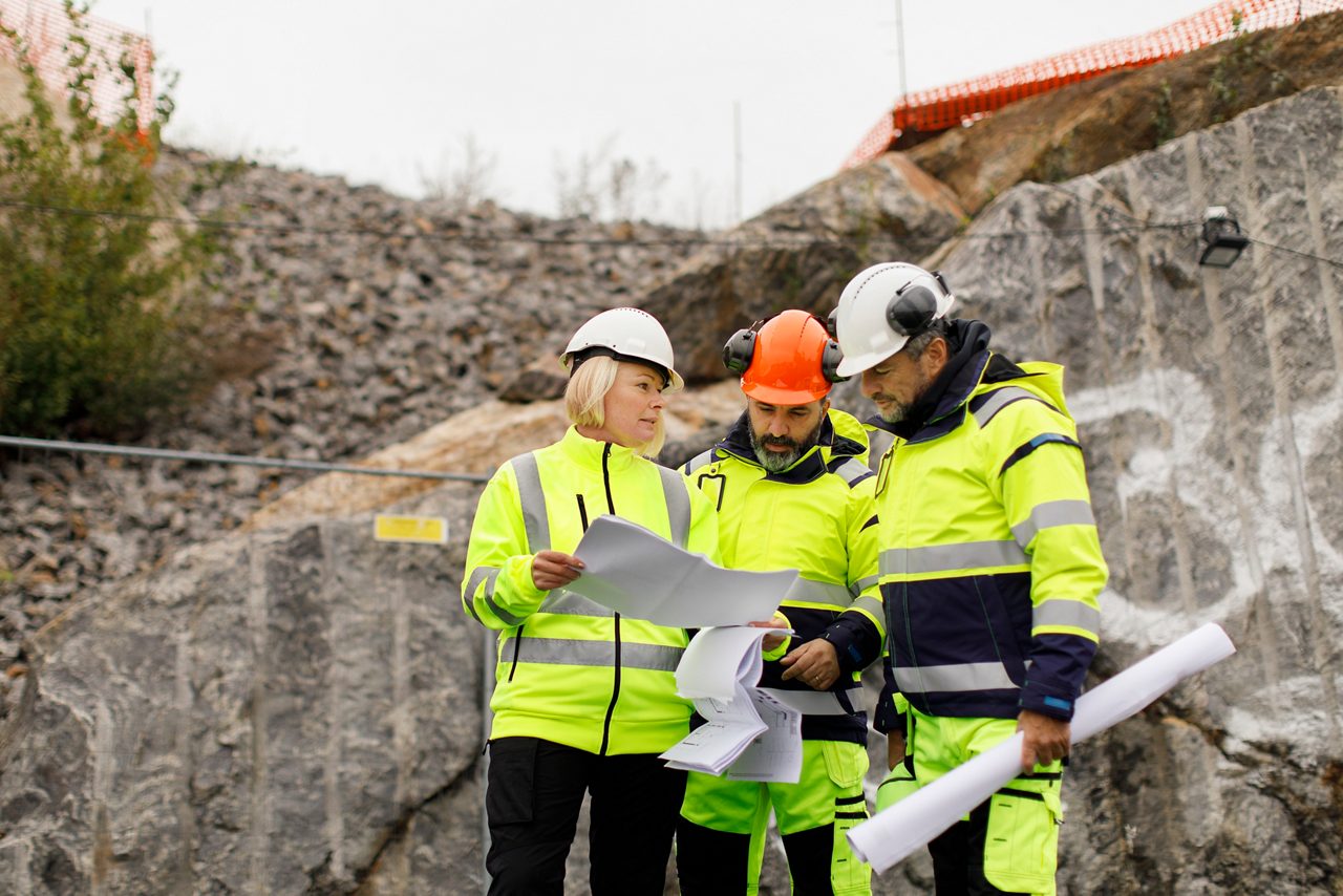 En grupp byggarbetare har ett planeringsmöte utomhus