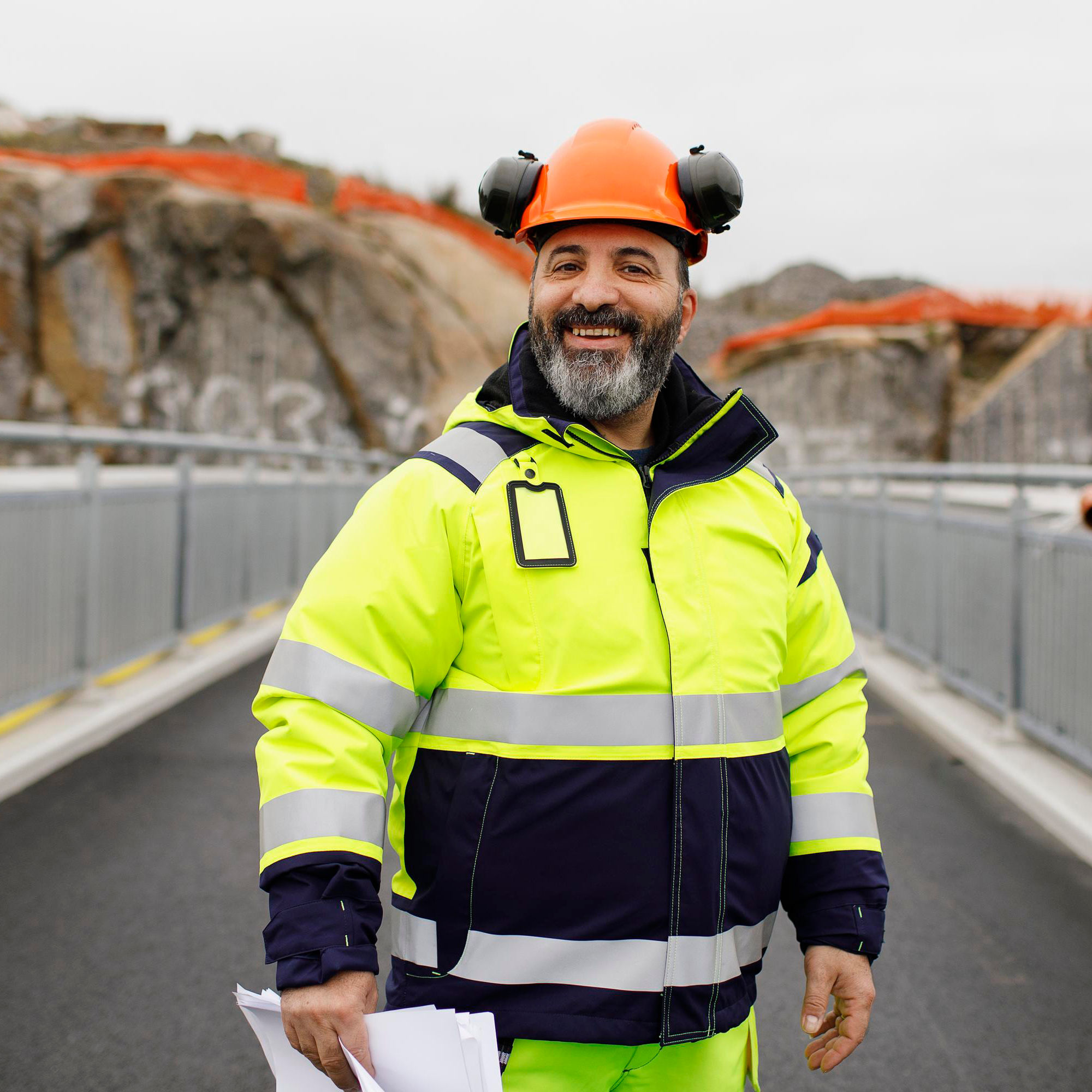 En byggarbetare i varselkläder står på en bro