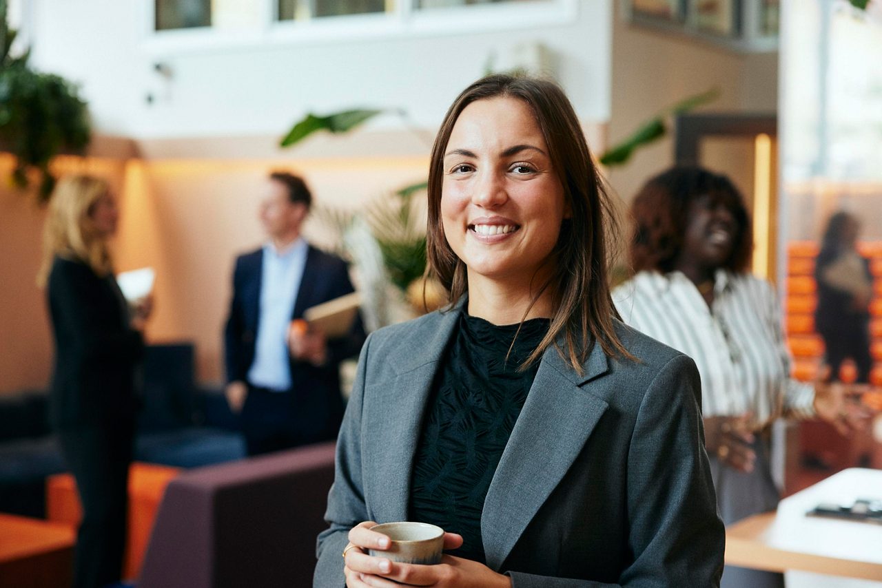 A woman holding a cup at office lobby