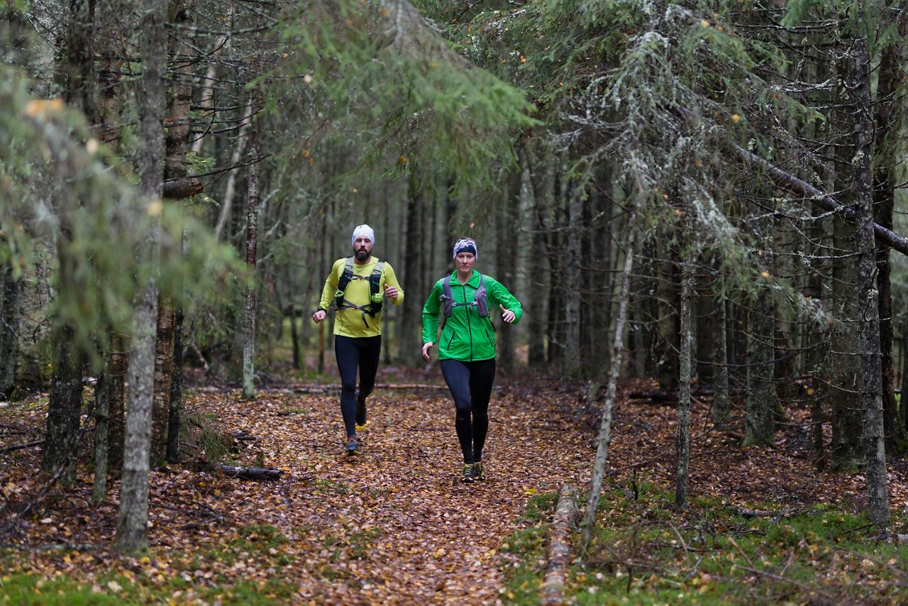Två personer på löptur i skogen