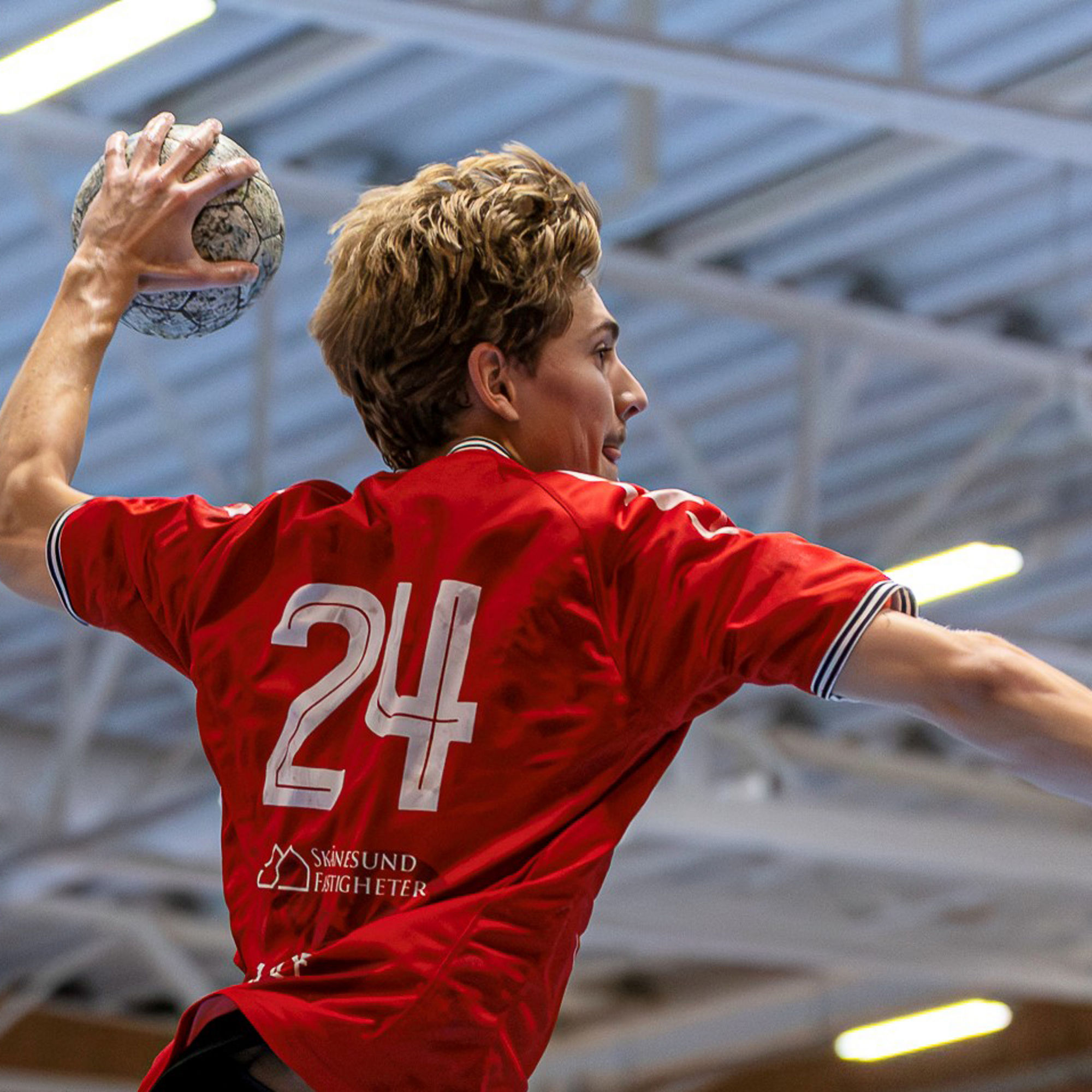 Handbollsspelare hoppar och kastar handboll