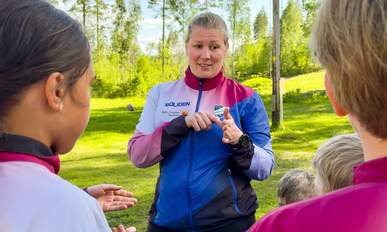 En tränare i Hedemora orientering talar med en barngrupp.
