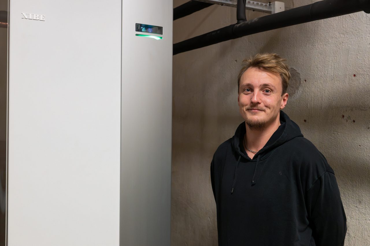 Jonathan Andersson bredvid nya värmepumpen från Sparbankskilowatten.
