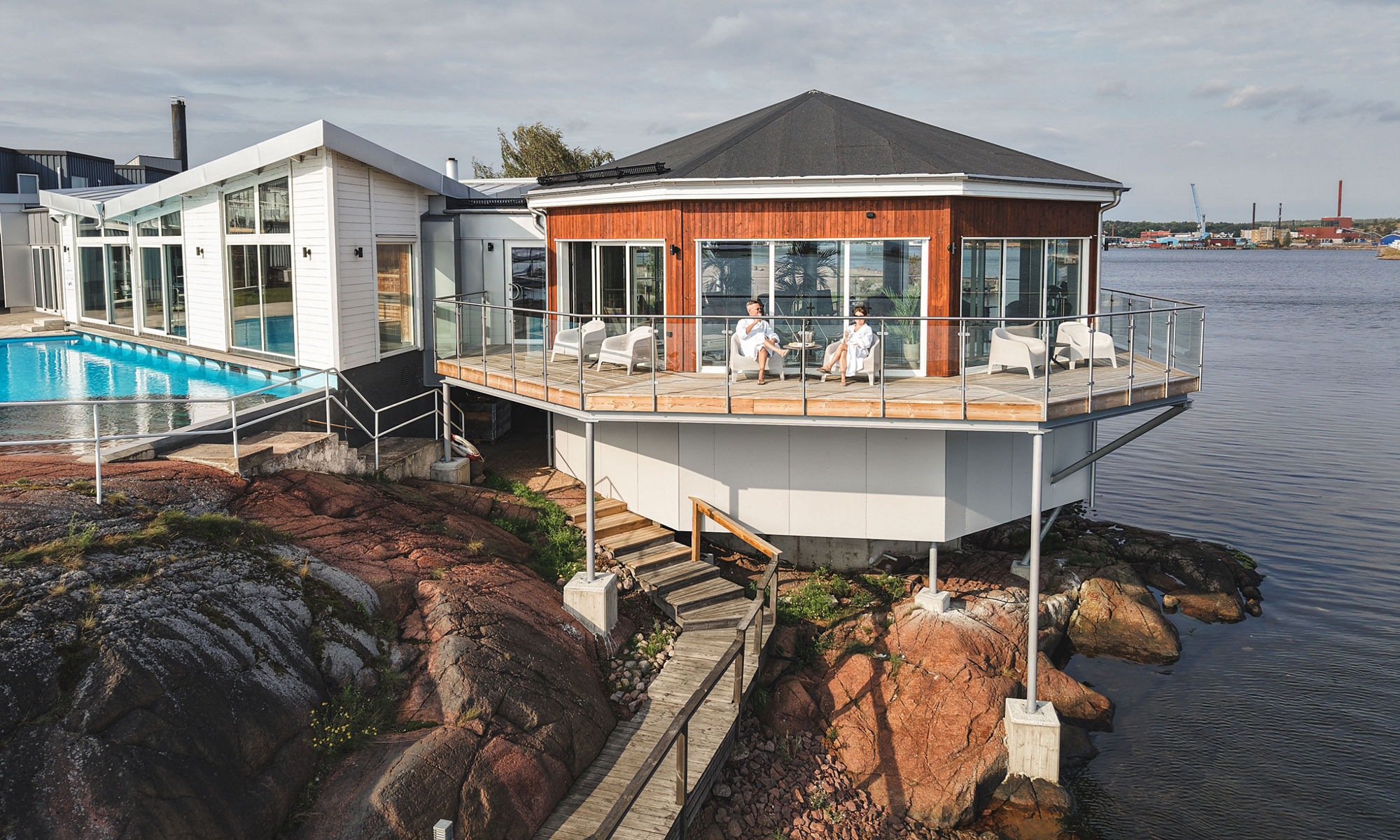 Modern spa-terrass vid vattnet på klippig strand