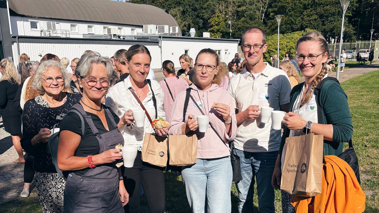 6 happy people drinking coffee outside