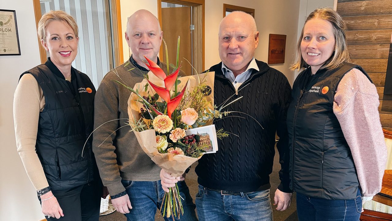 Ett foto på två män och två kvinnor med blommor