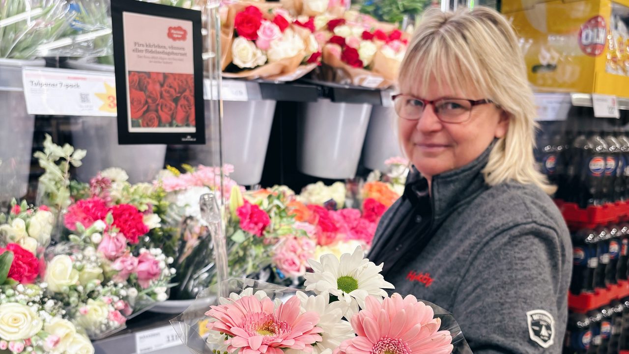 En kvinna som står och håller en blombukett