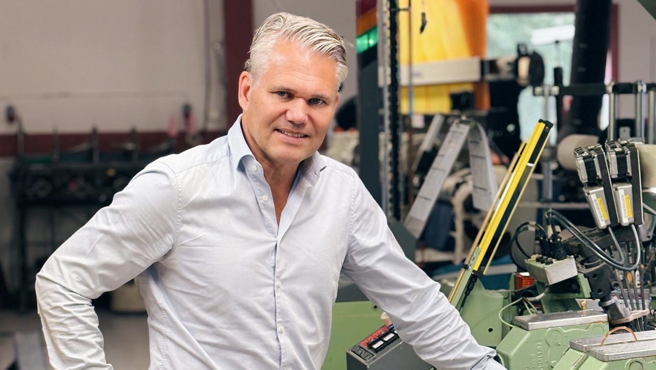 En man som står vid en maskin i en produktion på ett företag