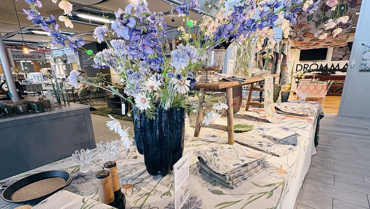 En bild på ett dukat bord med blommor och dekorationer