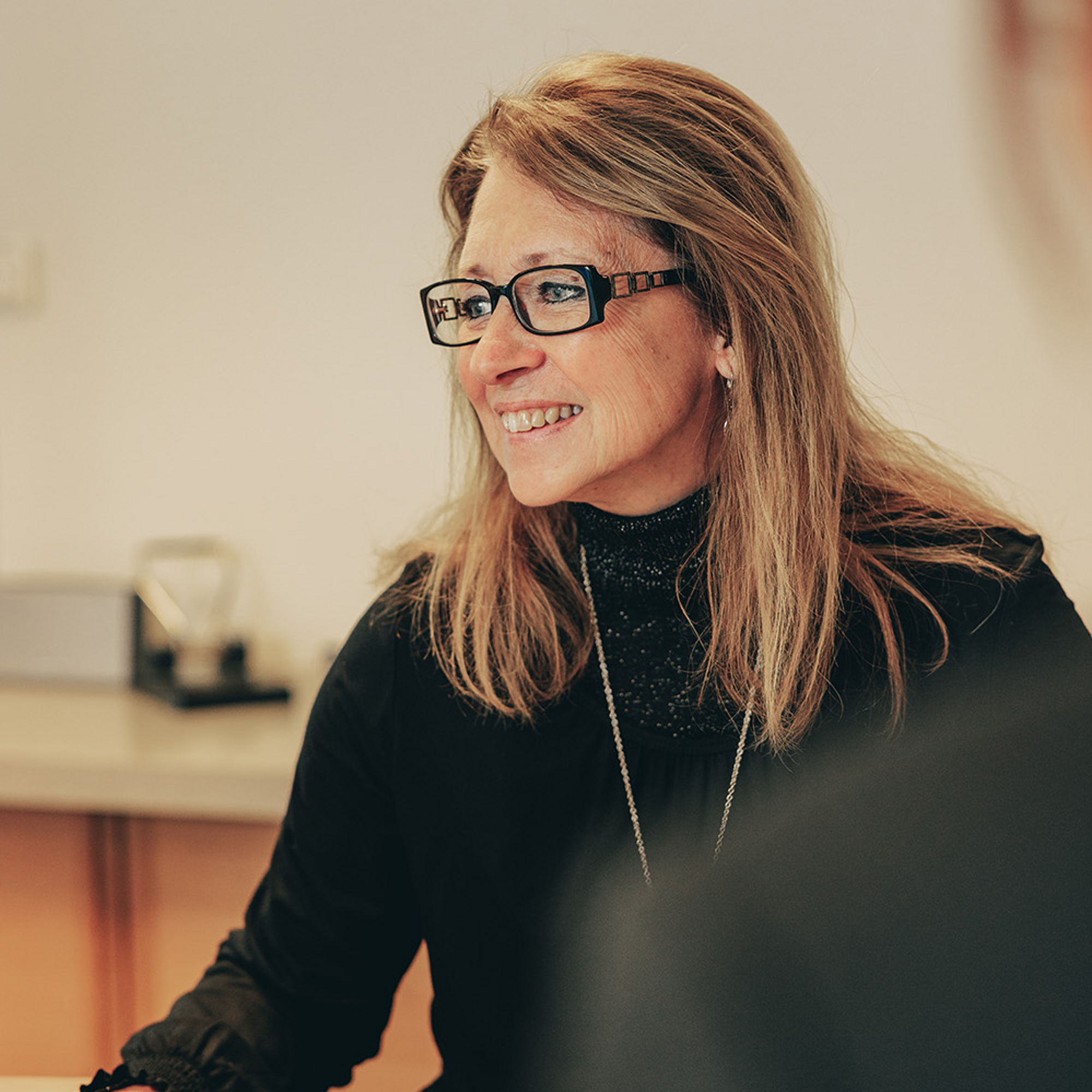 Inger sitter vid ett skrivbord och kollar på dataskärm