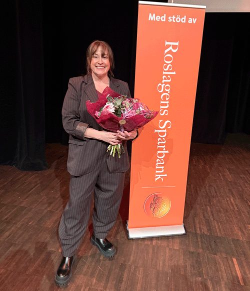 Bild på föreläsaren Petra Malm med en blombukett i famnen.