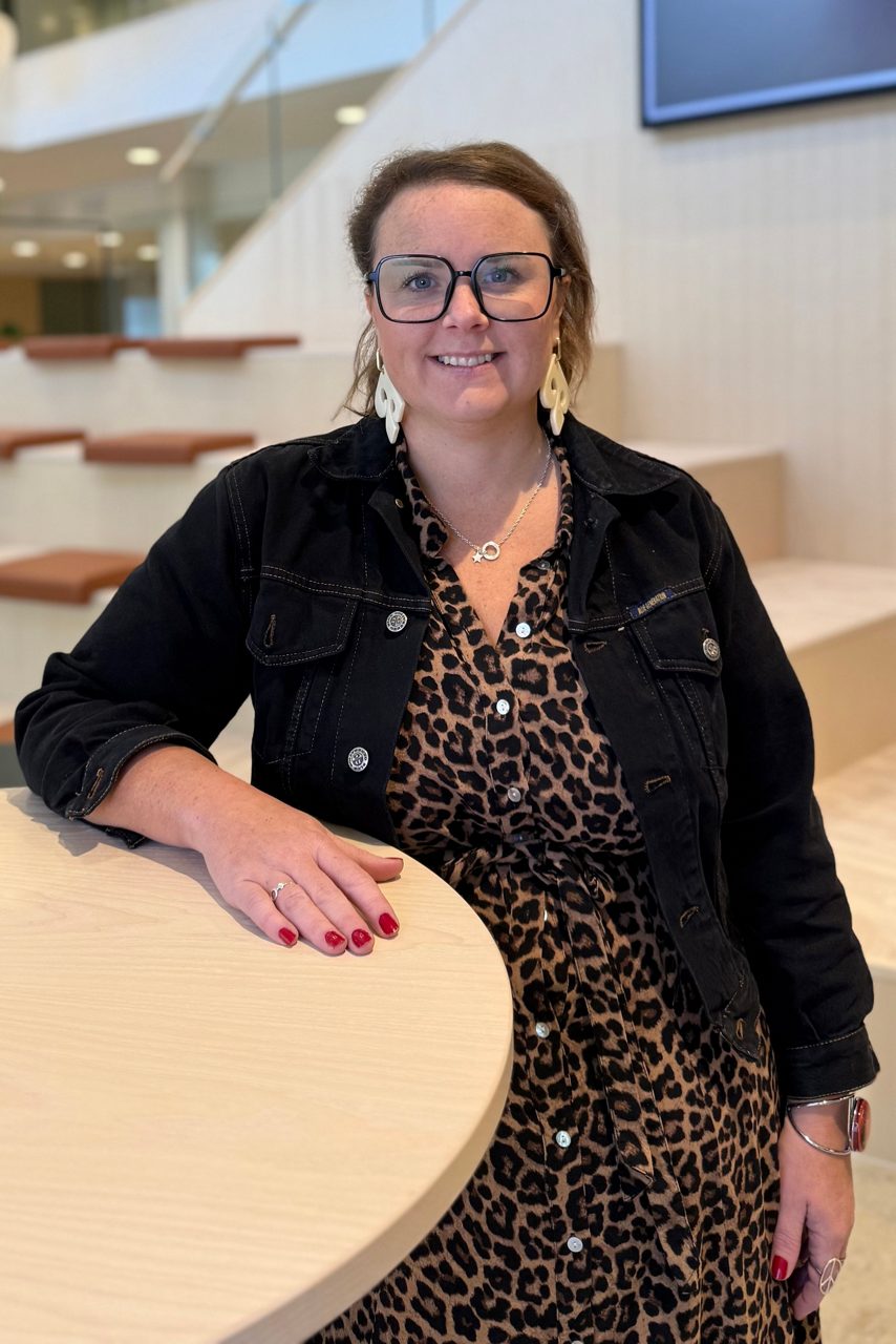 Kvinna tittar in i kameran och ler