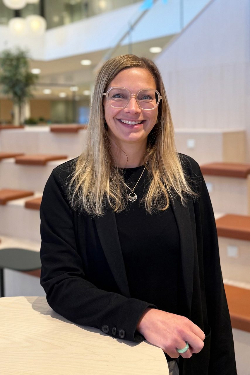 Kvinna tittar in i kameran och ler