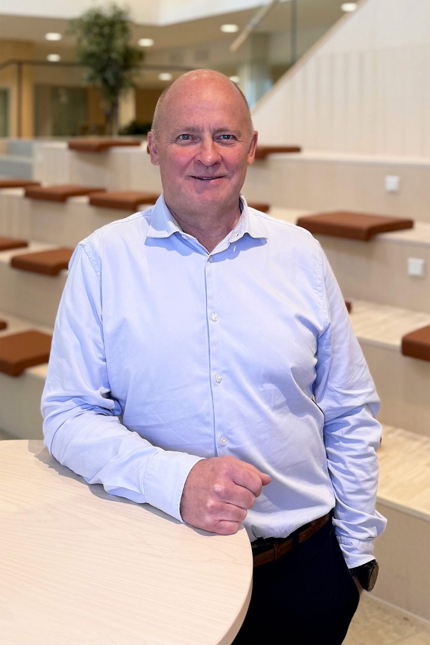 Man tittar in i kameran och ler