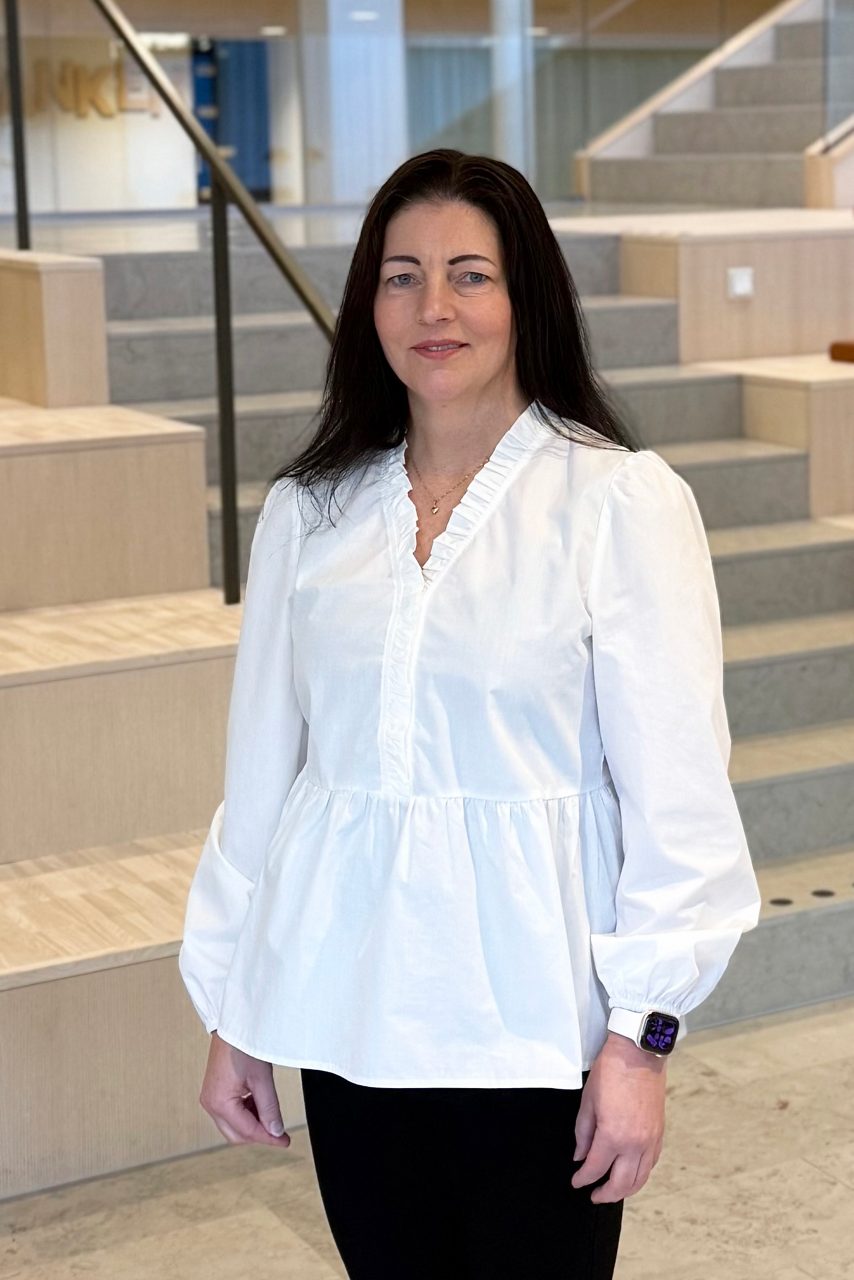 Kvinna tittar in i kameran och ler