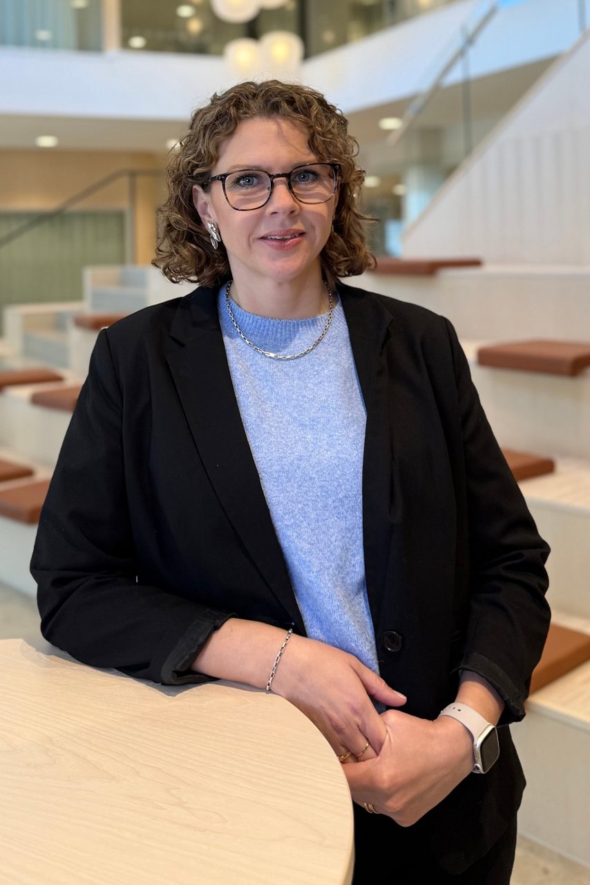 Kvinna tittar in i kameran och ler