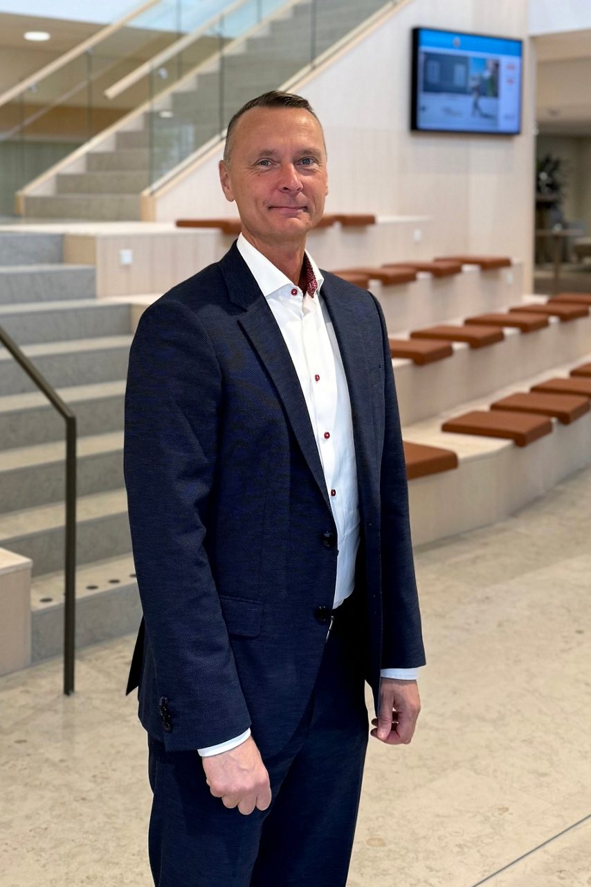 Man tittar in i kameran och ler