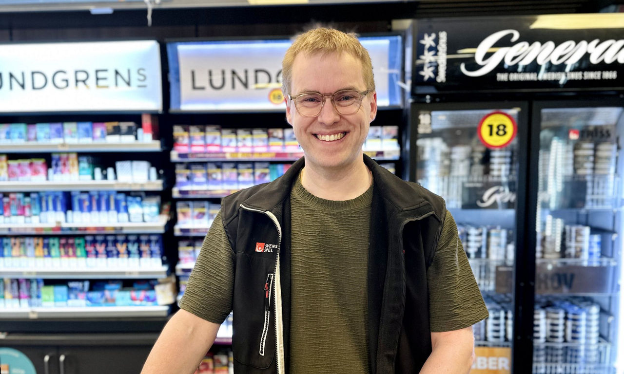 En lglad man som står bakom kassadisken i butiken Direkten