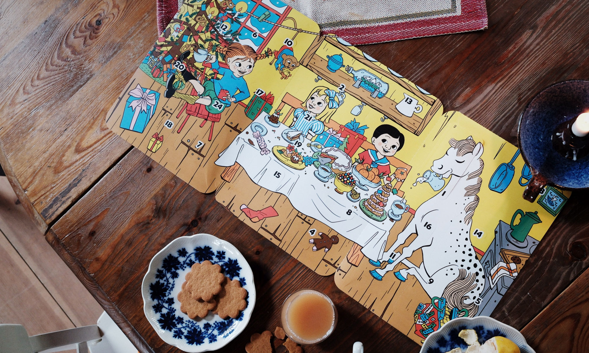 Nummerkalender med motiv Pippi som ligger på ett bord med kakor på ett fat brevid