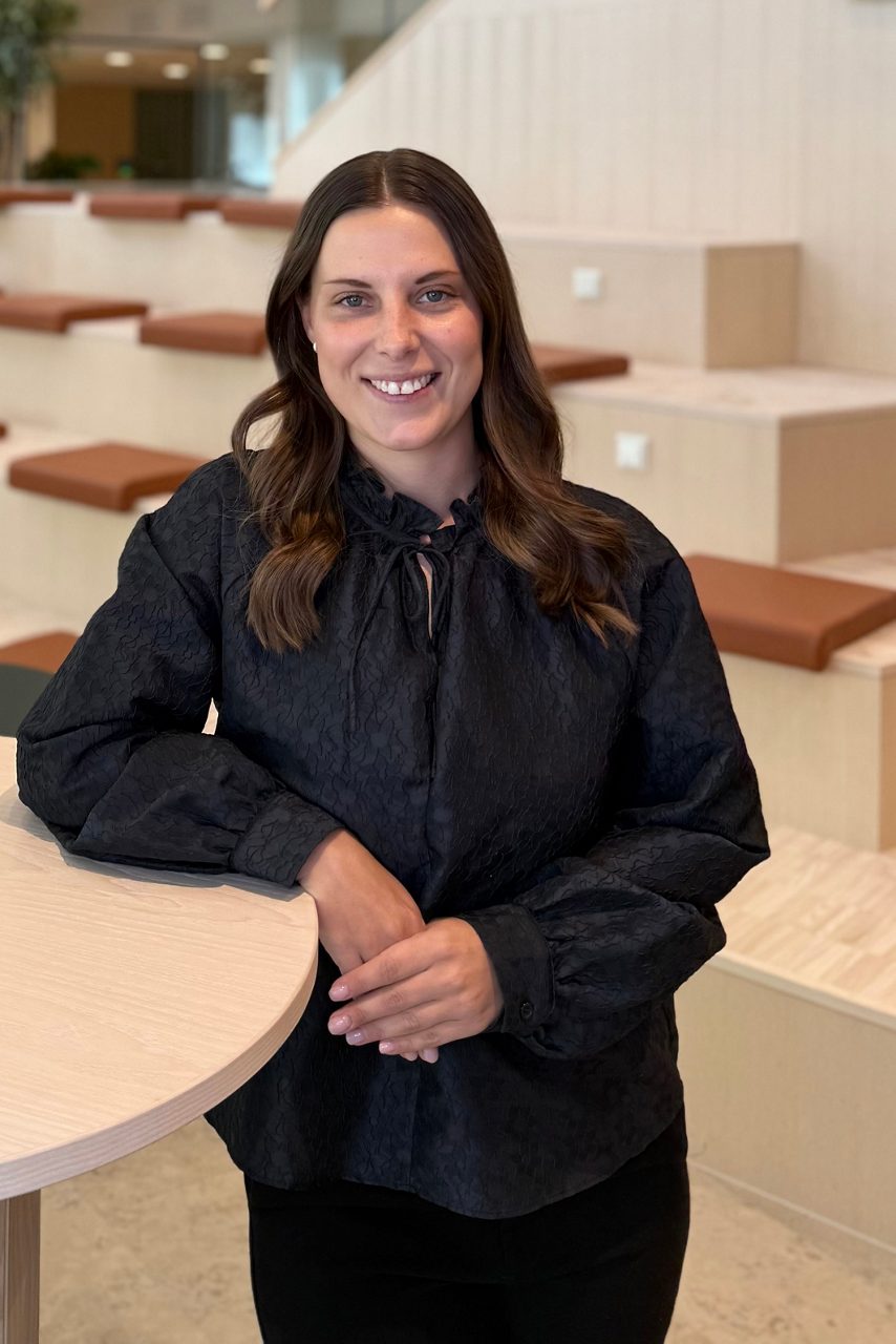 Kvinna tittar in i kameran och ler