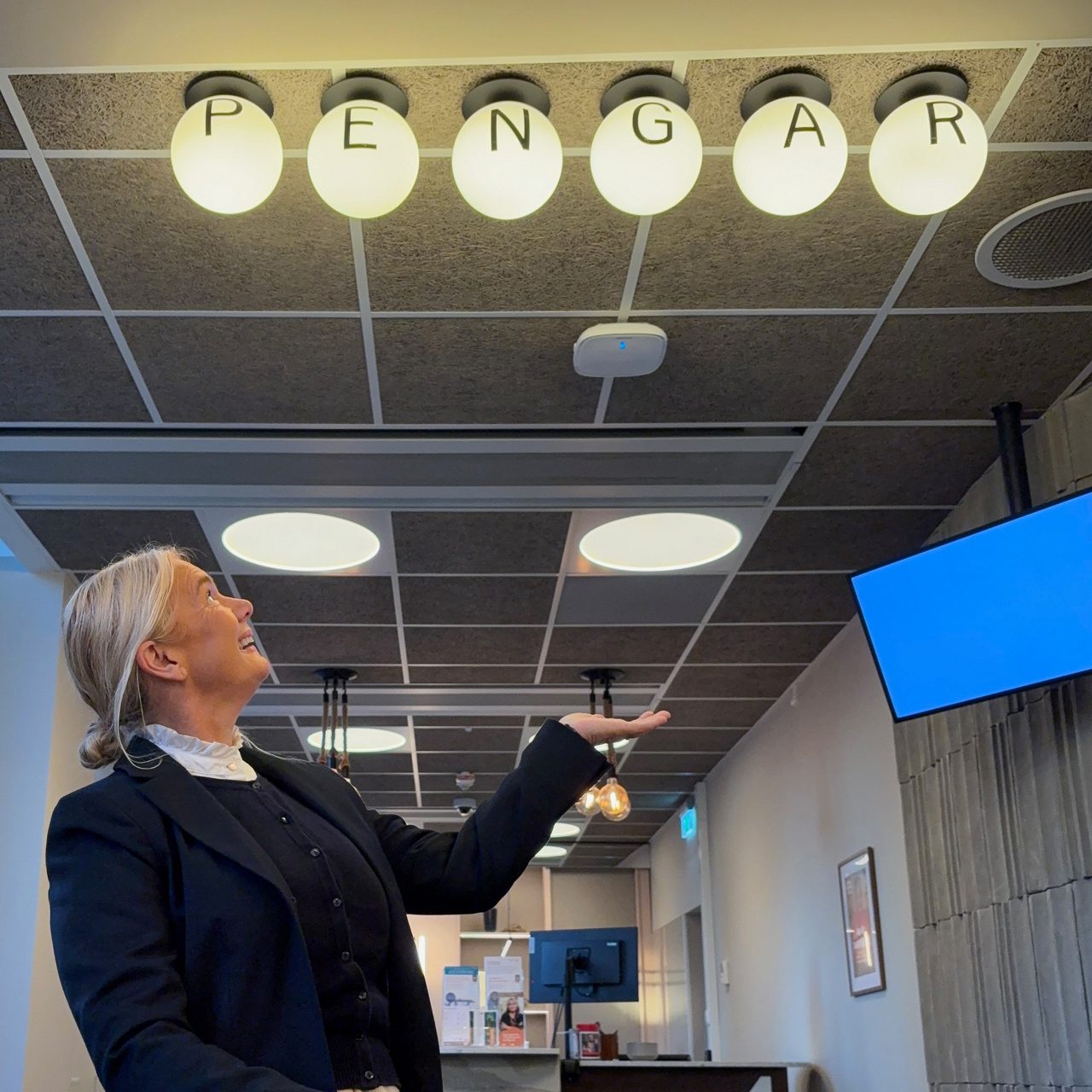 Louise tittar upp mot skylten "Pengar" i banksalen