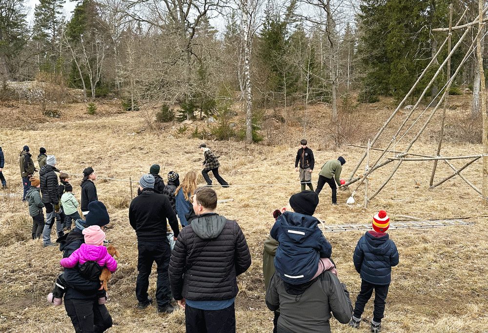 En grupp människor utomhus på hösten med en katapult