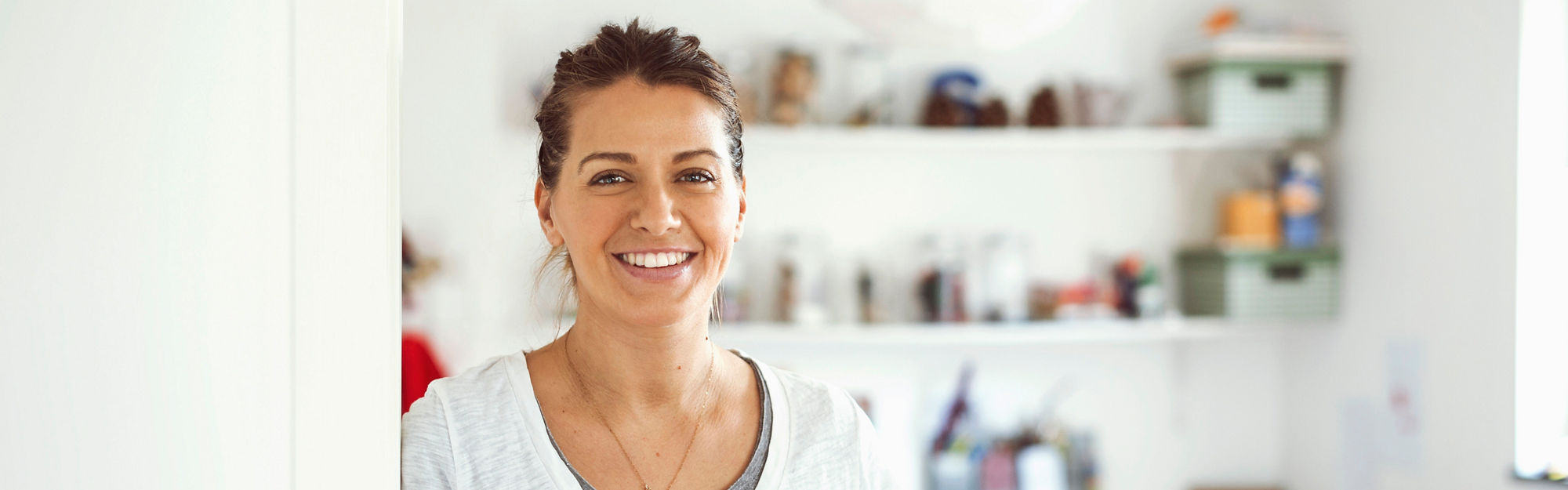 Smiling woman leaning her shoulder against a wall