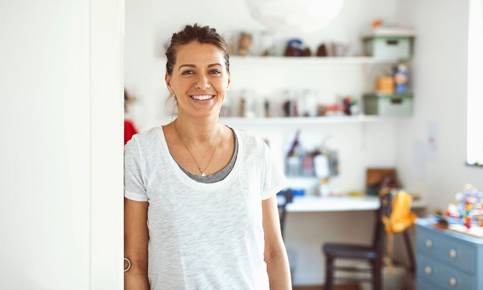 Smiling woman leaning her shoulder against a wall