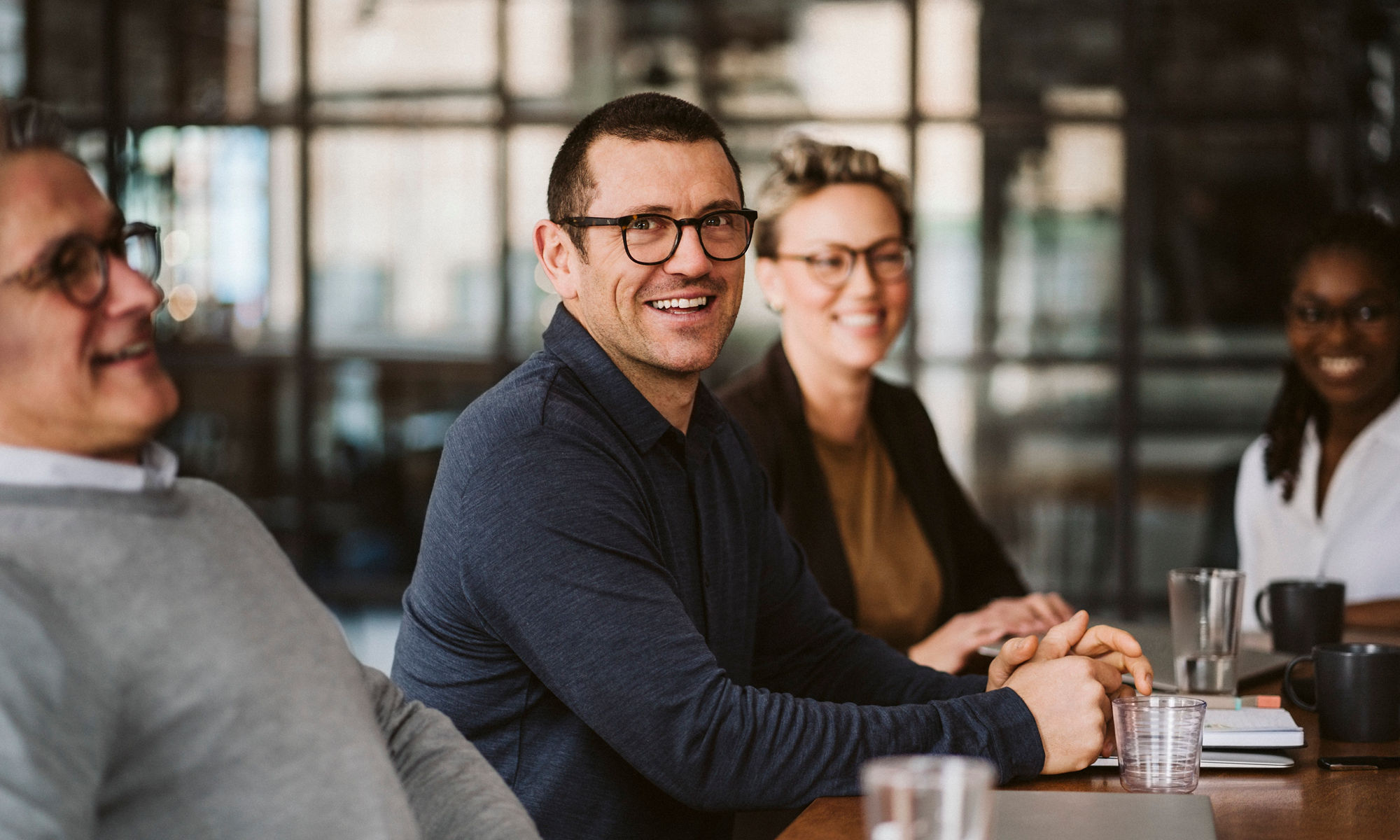 A group of people having a business meeting, all laughing