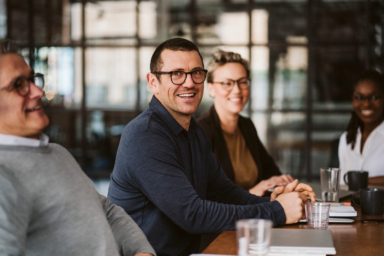 A group of people having a business meeting, all laughing