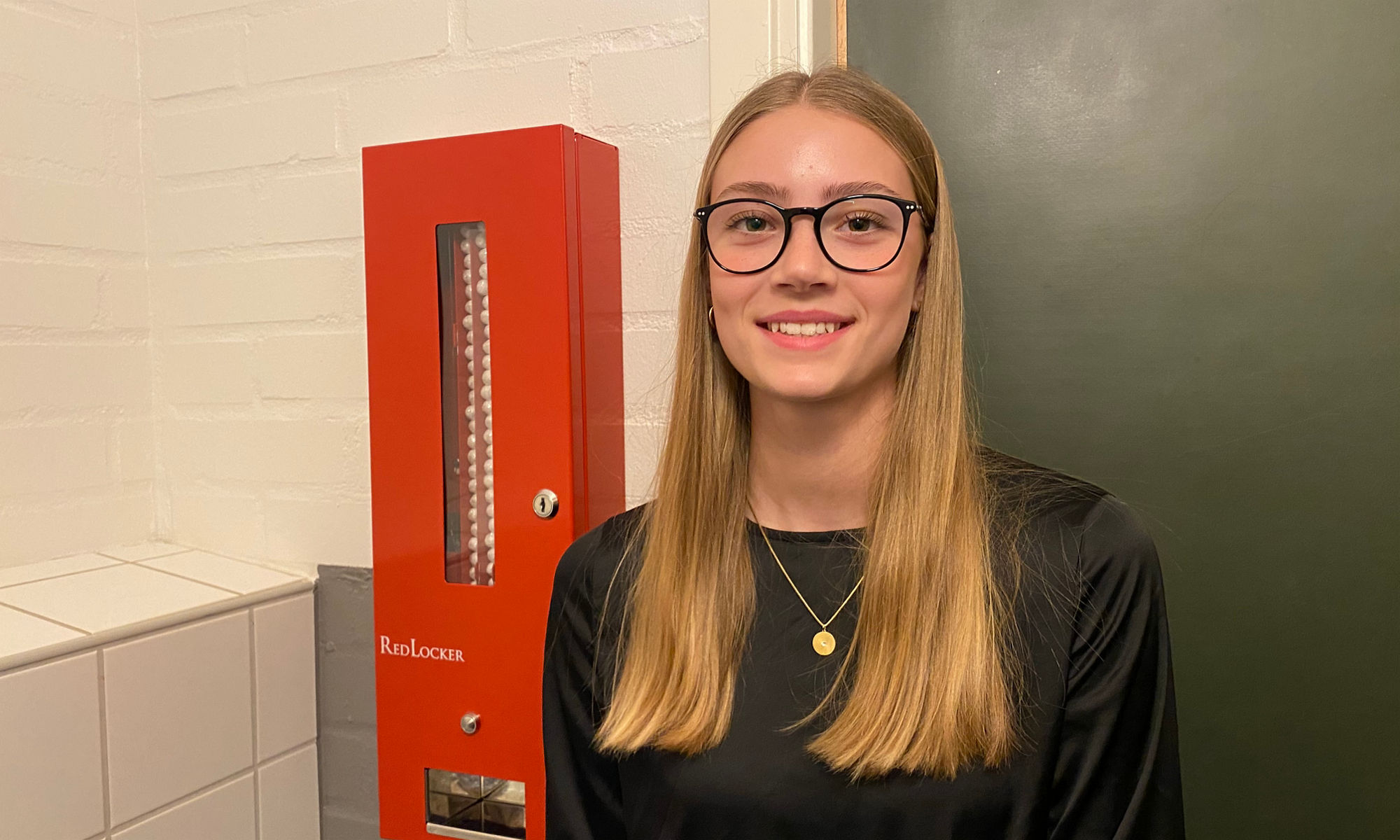 Elev står brevid en behållare med mensskydd på en skoltoalett..