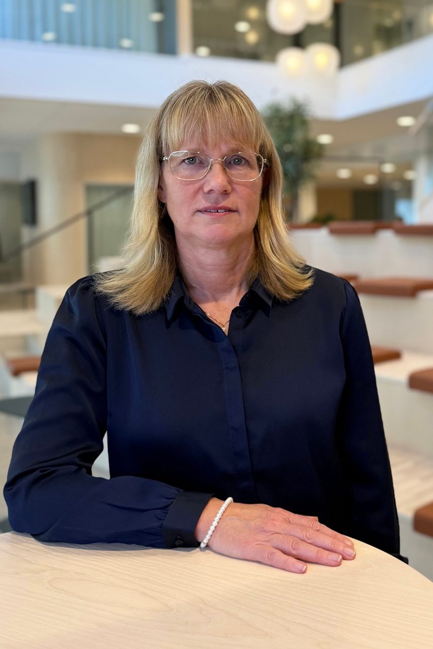 Kvinna tittar in i kameran och ler