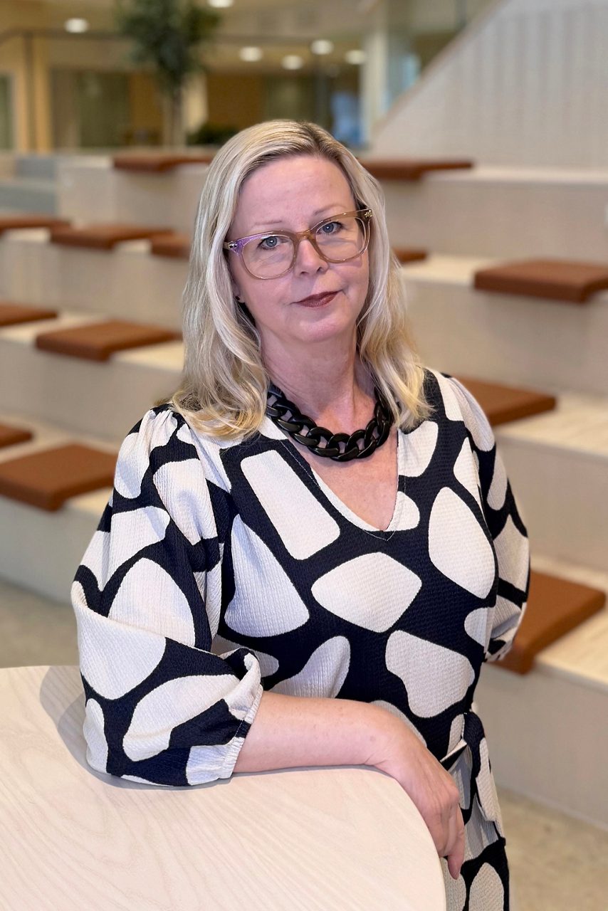 Kvinna tittar in i kameran och ler