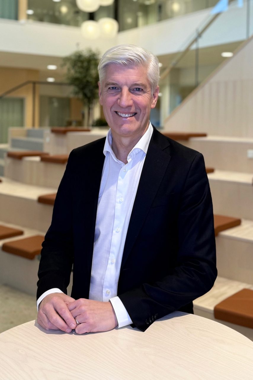 Man tittar in i kameran och ler