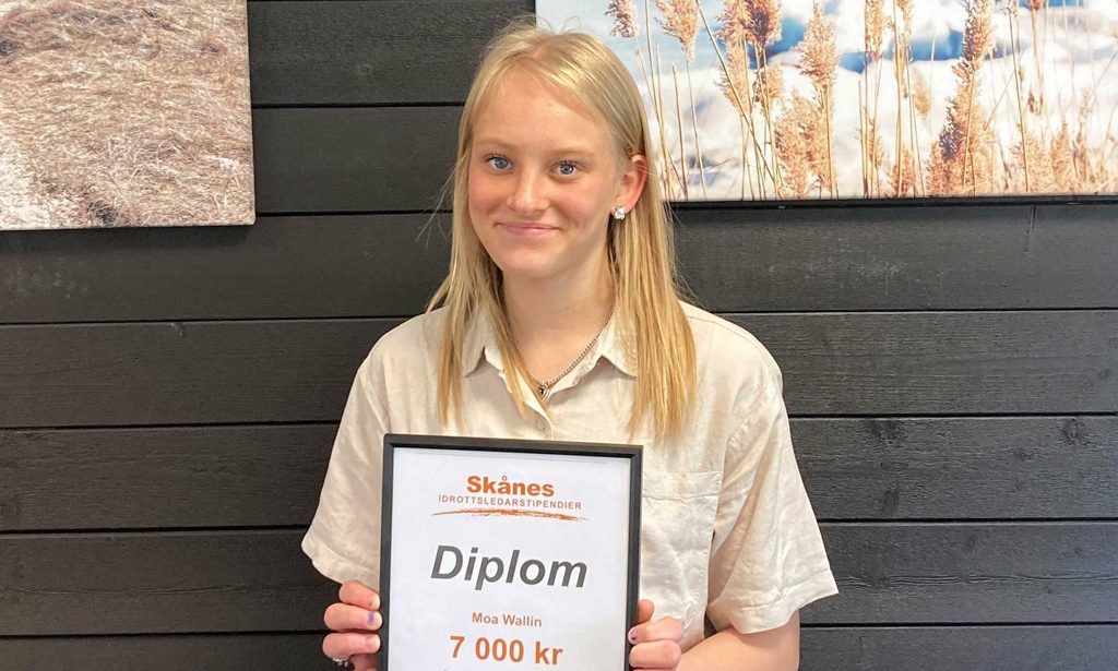 Moa Wallin håller sitt stipendium för Skånes Idrottsledarstipendium i sina händer.