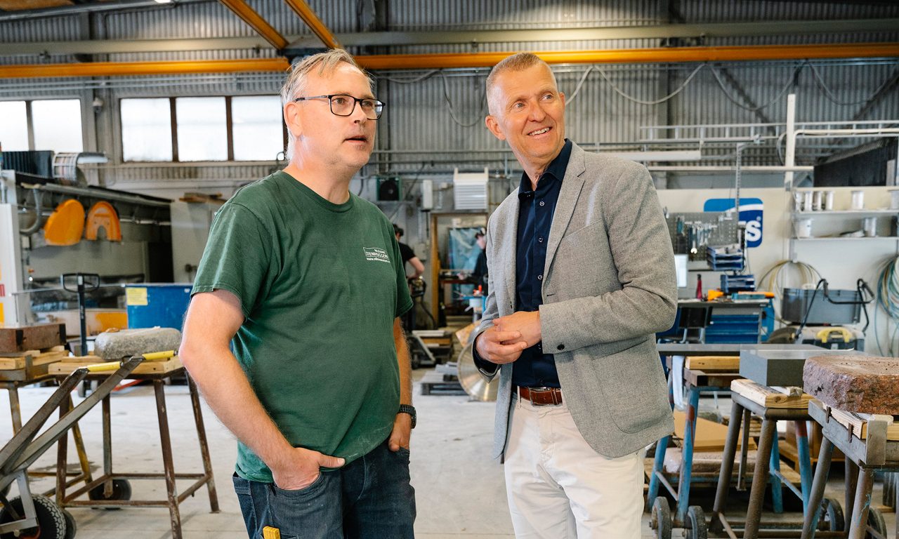 Niklas och Henric står inne i stenhuggeriet och tittar glatt snett bårt från kameran