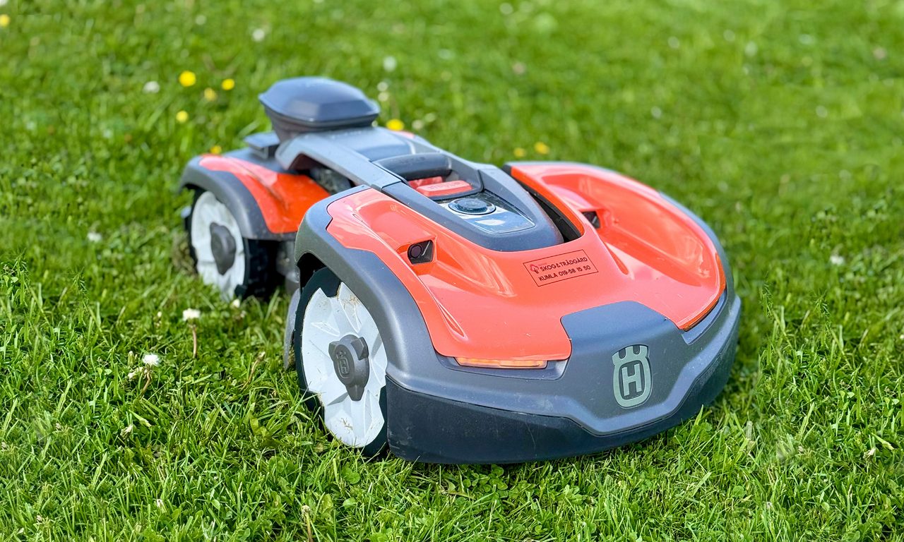 En soldriven gräsklippare som står på gräs.