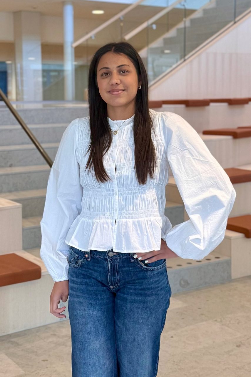 Kvinna tittar in i kameran och ler