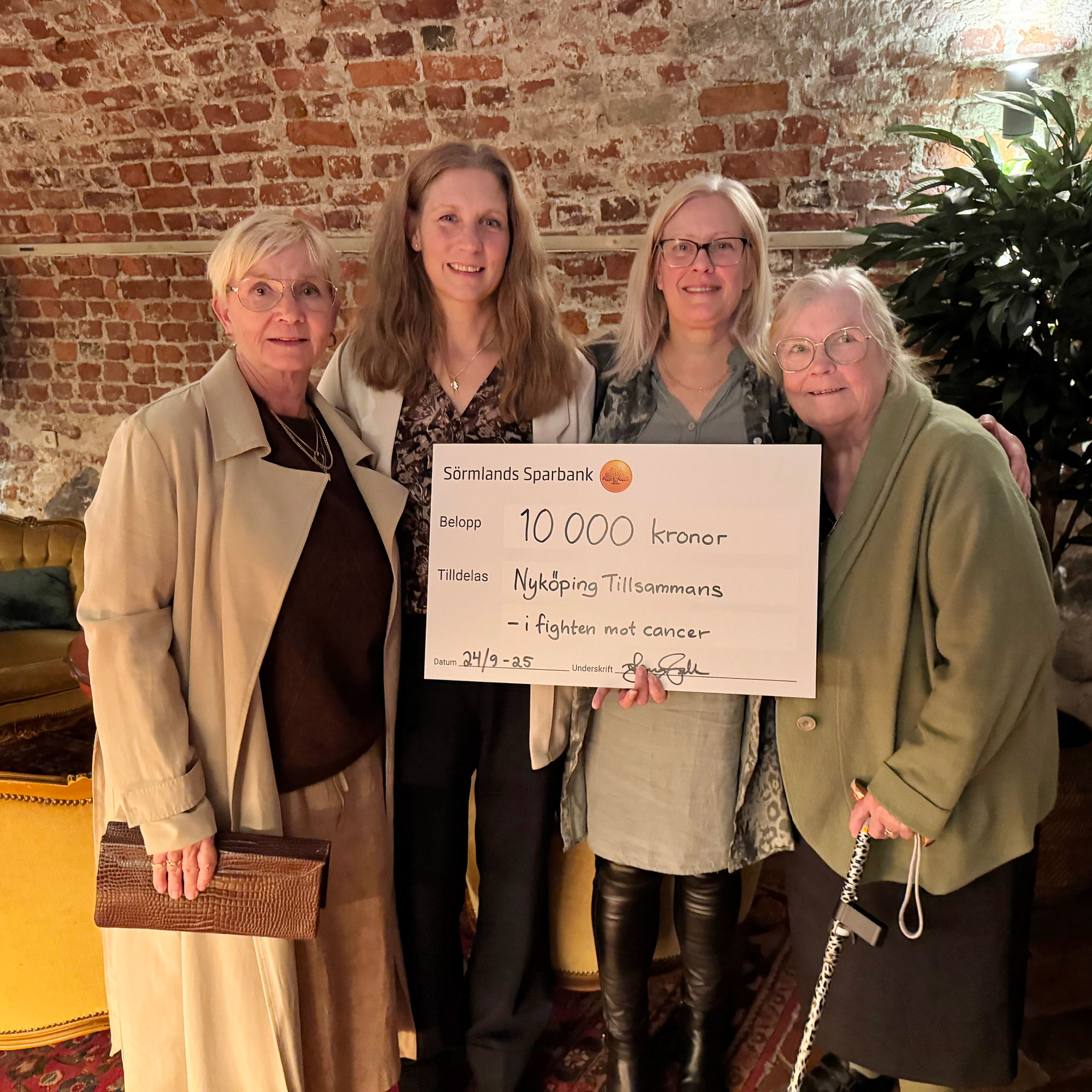 En grupp människor håller i en check