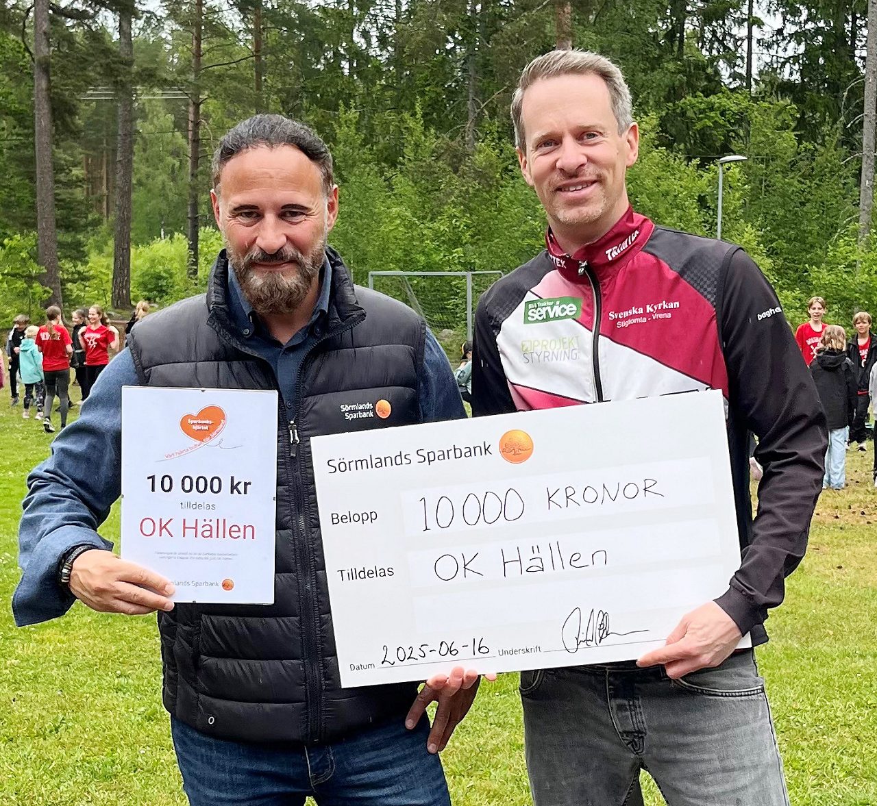 Två män med en check och ett diplom
