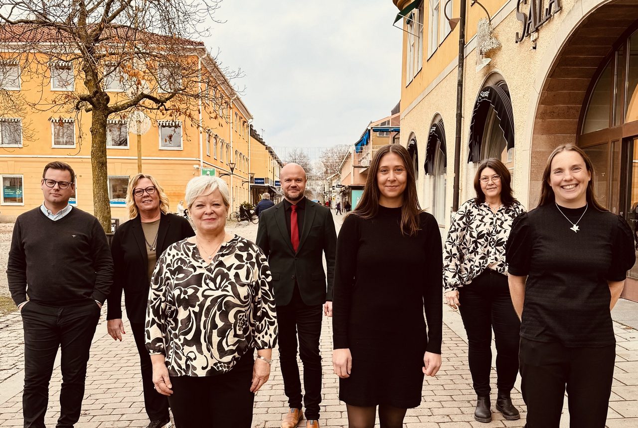 A group of people standing in front of the bank house.