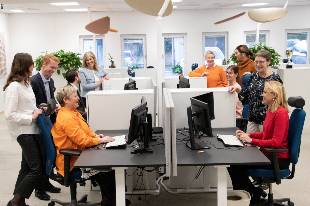 Blad bankpersonal runt skrivbord i öppet landskap