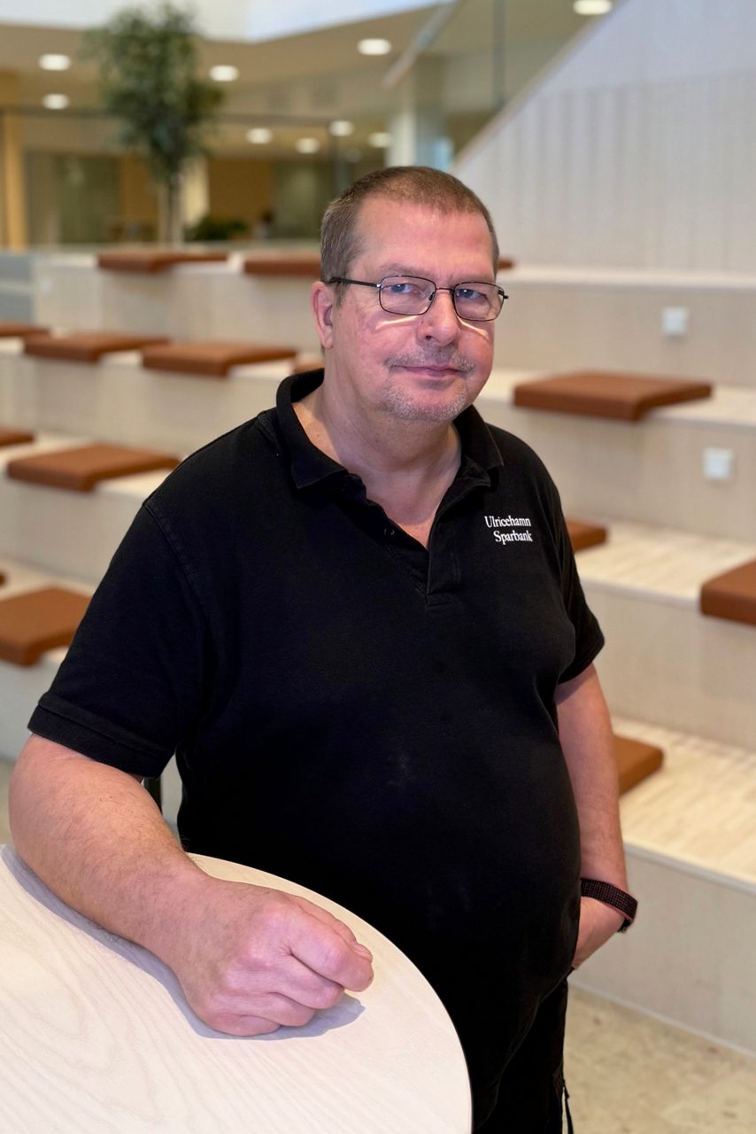 Man tittar in i kameran och ler